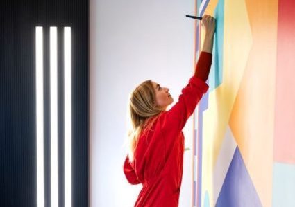 Blonde Frau malt an Wandgemälde