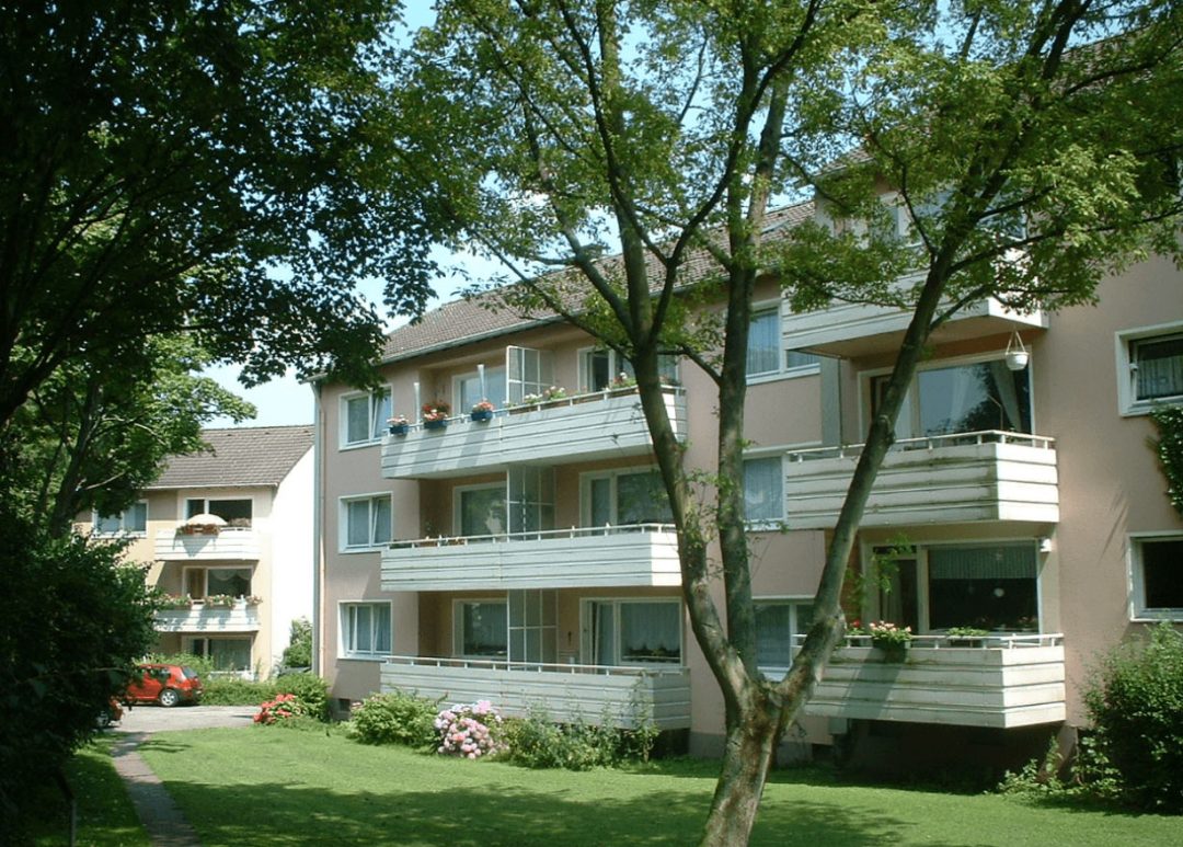 Mehrfamilienhaus mit Balkonen und Grünflächen