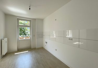 Küche mit Fliesenspiegel und Zugang zu Balkon